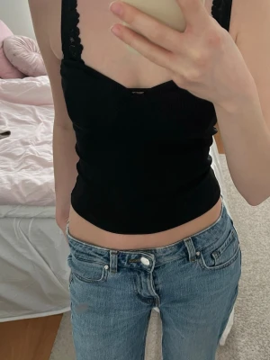 Svart ribbad bandeautopp - Säljer denna svarta ribbade bandeautopp med cropped och figurnära passform. 