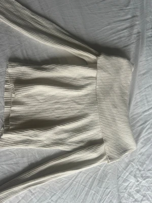 Vit ribbad tröja som går att vika ner - Snygg vit tröja som går att vika ner, den är i mjukt material och är i xs från hm. Den är stretchig så den hade kunnat passa s också. Skriv för mer frågor💕