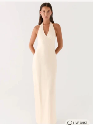 Maxi klänning i satin - Jätte fin klänning  i storlek 34 som passar till balen i en pärl färg från Peppermayo, kommer inte till användning . Man kan knyta banden lösare och hårdare så passar för fler storlekar. Helt ny!