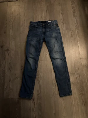 Blåa Replay Anbass - Säljer ett par blåa Replay Anbass jeans som är i slimfit, och är i storlek 29x32, finns några skavanker men inget man tänker på när man bär dom