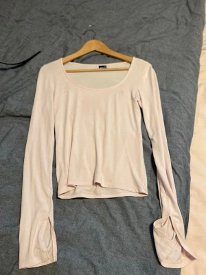 Ljusrosa långärmad topp - Snygg ljusrosa långärmad topp med rundad urringning och mjukt, stretchigt material. Perfekt att styla med jeans eller kjol för en enkel men trendig look.