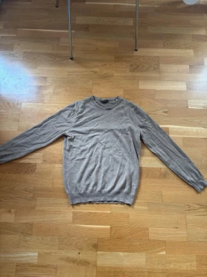 Beige stickad tröja från Stenströms - Säljer en stilren beige stickad tröja från Stenströms. Tröjan har rund halsringning, långa ärmar och ribbade muddar vid ärmslut och nederkant. Perfekt för lager på lager och enkel att matcha med olika outfits. Liten i storlek 