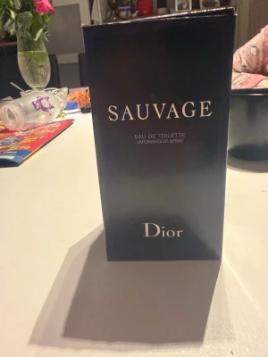Dior Sauvage Eau de Toilette - Dior Sauvage Eau de Toilette är en ikonisk herrparfym med fräsch och kryddig doft. Flaskan är cylindrisk i glas med svart och transparent toning, och har en stilren svart kork. Förpackningen är elegant och svart med silverfärgade detaljer.