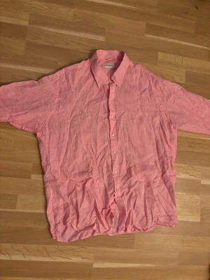 Rosa linneskjorta från John Henric - Snygg rosa skjorta från John Henric i luftigt linne. Klassisk krage, knäppning framtill och lång ärm. Perfekt för en avslappnad men stilren look.