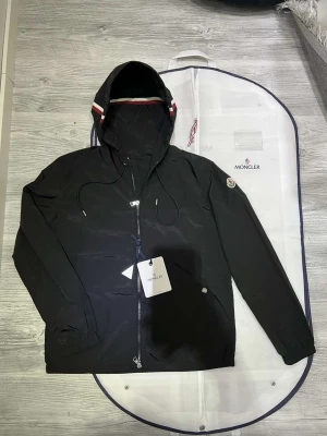 Moncler windbreaker - Hejsan! Jag säljer nu min moncler windbreaker som är i jättefint skick den är andvänt väldigt lite och sparsamt den har inga defekter eller liknande. dustbag moncler plastpåse och og taggarna ingår med den. Den är äkta och köpt ifrån Nk och kvittot finns kvar, priset är hugget i sten. Storleken är i moncler 2. Hör av dig vid minsta lilla fundering!😄🙌