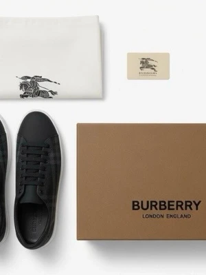 Burberry svart-rutiga sneakers - Snygga sneakers från Burberry i svart med klassiskt rutmönster och vita sulor. Skorna har svarta skosnören, rund tå och detaljer i läder. Perfekta för dig som vill ha en stilren och exklusiv look med en touch av brittisk design. (Pris kan diskuteras)