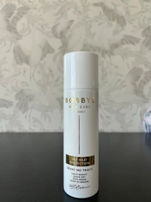Bobby's värmeskydd för håret - Värmeskyddsspray från Bobby's Hair Care i vit flaska med gulddetaljer. Produkten är lätt, torkar snabbt och lämnar inga spår. Perfekt för att skydda håret vid styling med värmeverktyg. Tillverkad i Sverige. Säljer då jag inte använder värme på håret. Självklart oanvänd.
