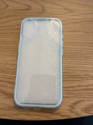 Transparent mobilskal till iPhone 17 - Snyggt och stilrent transparent mobilskal med mjuka kanter, perfekt för dig som vill visa upp din mobil samtidigt som du skyddar den. Skalets material är flexibel TPU och det har en upphöjd kant runt kameran för extra skydd.