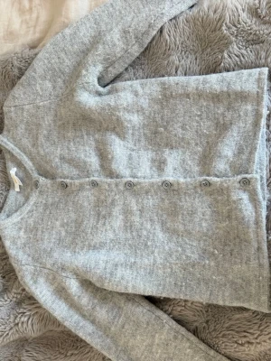Ljusgrå stickad kofta med knappar🤍 - Ljusgrå stickad kofta med rund hals och knappar längs hela framsidan. Koftan har långa ärmar och är gjord i ett mjukt material som känns skönt mot huden. köpt på Gina tricot för ungefär ett år sedan, storlek 146-152.🤍