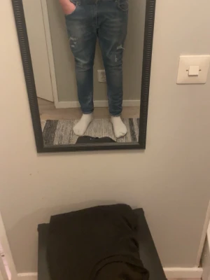 Blå slim fit jeans från Dondup - Säljer ett par blå slim fit jeans från Dondup med slitningar och lätt tvättad look. Jeansen har klassisk femficksdesign, normal midja och smala ben. Perfekta för dig som gillar en trendig och avslappnad stil. Stl 33 i midjan och 30 L, skriv vid intresse! 