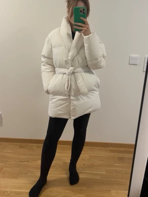 XS/S belted jacket - Cream belted puffer jacket Size XS/S Warm and lightweight Flattering wrap style with waist belt Very good condition Small marks on inner lining (not visible when worn) Fast shipping from Gävle Size XS-S Bust: 76-90 cm Waist: 55-67 cm Hips: 79-93 cm