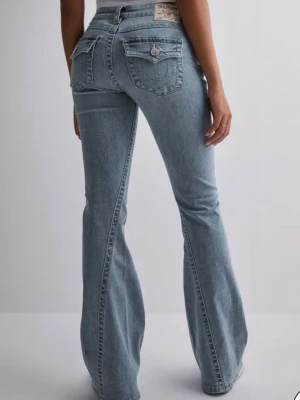 Bootcut jeans från True Religion - Blåa low rised true religion jeans i storlek w25 som är lite för stora för jag har w24💕. Den har lite märkbara sltningar vid slutet av bootcuten och lite högra upp också💓 Kontakta bara om ni vill ha bild🥰 
