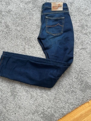 Mörkblå Jacob cohen jeans - Snygga mörkblå jeans från Jacob cohen med klassisk femficksdesign och kontrastsömmar. Jeansen har en smal passform. Längd: 97cm midja: 38cm