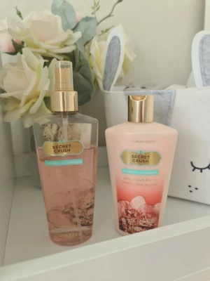 Victoria's Secret Secret Crush parfymset - Säljer ett parfymset från Victoria's Secret i doften Secret Crush. Setet innehåller en rosa body mist i plastflaska med guldfärgad spraykork och en matchande body lotion i ljusrosa plasttub med guldfärgat lock. Båda har blommiga och fruktiga toner. Parfym har blekts och krämen är knappt använd. Säljer nu av min vintage kollektion. Perfekt för samlare. Eftersom dofterna är vintage kan lukten skilja sig markant från nya, och köps därmed på eget bevåg. Bucklig förpackning 