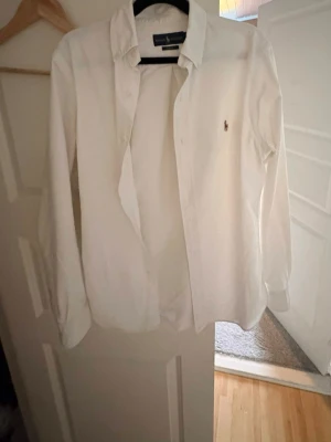 Ralph lauren skjorta vit (S) -  Säljer en Ralph Lauren skjorta i storlek S i bra skick. Klassisk och stilren vit skjorta med broderad Ralph Lauren-logga på bröstet. Perfekt för både vardag och mer uppklädda tillfällen. Skjortan är tillverkad i hög kvalitet med bekvämt material och har en tidlös passform. 🔹 Märke: Ralph Lauren 🔹 Modell: Skjorta 🔹 Färg: Vit 🔹 Storlek: S 🔹 Skick: Bra skick 🔹 Passform: Klassisk Säljs till ett bra pris – perfekt chans att göra ett fynd. 