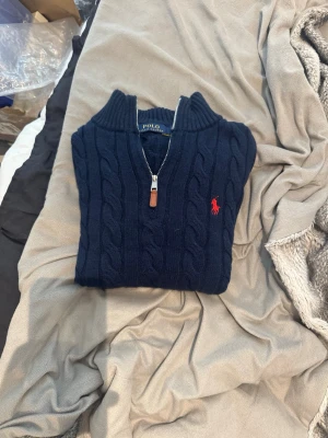 Mörkblå kabelstickad tröja Polo Ralph Lauren - Tjena säljer en Mörkblå kabelstickad tröja från Polo Ralph Lauren med halv dragkedja och ribbad krage. Fick den i födelsedags present o passa inte därav säljer jag den. Hör av er vid minsta fråga eller prisförslag så diskuterar vi ❗️