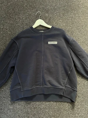 Mörkblå sweatshirt  - Säljer en mörkblå sweatshirt med rund halsringning och synliga sömmar. Tröjan har en relaxed fit. 