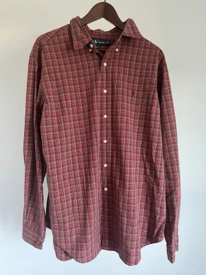 Ralph Lauren Classic Fit Skjorta - Ralph Lauren Classic Fit Skjorta Storlek: XL Passform: Classic Fit Krage: Button-down Material: 100% bomull Mått: Bröstvidd 120 cm, längd 82 cm, axel 52 cm Skick: Skjortan är i ett väldigt fint skick utan defekter  Nypris cirka: 1 500 kr