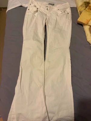 Vita bootcut jeans från 157 - Säljer ett par vita bootcut jeans från 157 med klassisk femficksmodell och normal midja. Jeansen har vida ben och är tillverkade i ett mjukt bomullstyg med stretch. Perfekta för dig som gillar en clean och fräsch look.