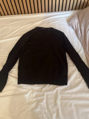 Svart tröja från Jack & Jones XS - En stilren svart tröja från Jack & Jones i storlek XS. Tröjan har rund halsringning och långa ärmar, perfekt för en clean och enkel look. Passar till det mesta och är lätt att matcha med andra plagg.