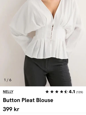 Vit blus med knappar från Nelly - Aldrig använd blus från Nelly i storlek 34