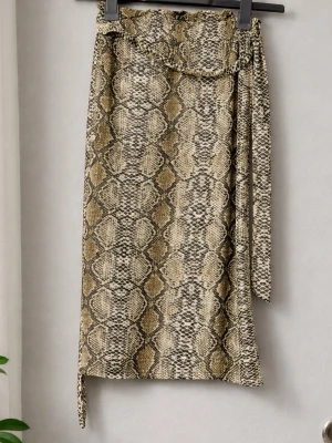 Kjol med ormmönster Shein - Trendig långkjol med snyggt ormmönster i beige, bruna och svarta toner. Kjolen knyts i midjan med ett matchande band. Perfekt för dig som vill sticka ut med en cool stil.