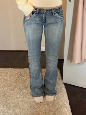 Ljusblå bootcut jeans med brodyr - Snygga ljusblå bootcut jeans med broderade detaljer längs ena benet. Jeansen låg midja och en lätt urtvättad stil. Lite coolare jeans och lite unikare inte alla som har dom. Super bekväma eftersom materialet är väldigt stretchigt🤗💕