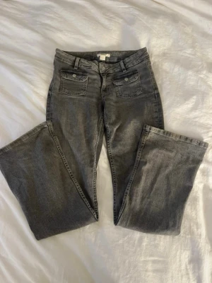 Grå bootcut jeans - Snygga grå bootcut jeans med två fickor framtill med lock och knappar. Perfekta för dig som gillar en avslappnad men trendig look. (pris kan alltid diskuteras)💕storlek 158