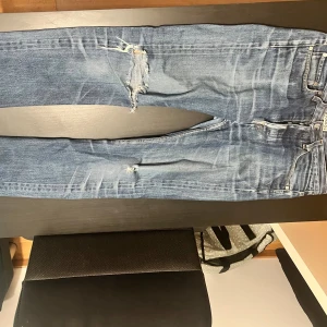 Blå slitna jeans från Acne Studios - Btw litet hål vid skrevet. Säljer ett par blå jeans från Acne Studios med slitningar och hål på knäna. Jeansen har klassisk femficksdesign, raka ben och Skitfet tvätt modellen är 178 och väger 70 kilo. 