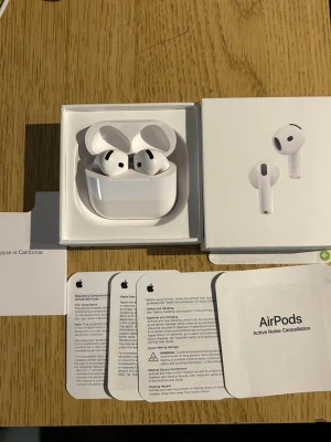 Apple AirPods 4 - Säljer ett par vita Apple AirPods 4 med aktiv brusreducering. Trådlösa hörlurar i klassisk Apple-design med laddningsetui. Kommer med originalförpackning och manualer. 1:1 