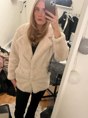 Beige pälsjack - Säljer en supermjuk och fluffig beige pälsjacka . Jackan är perfekt nu inför våren. Stängs framtill och har diskreta fickor på sidorna.