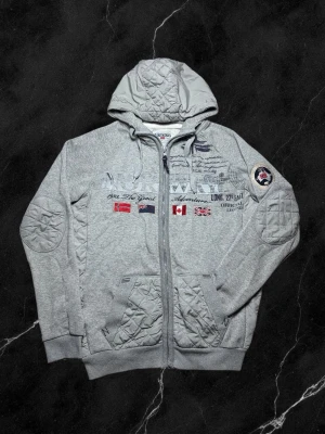 Vintage Geographical Norway hoodie ”Golfstream” - herr strl L - Säljer en vintage Geographical Norway hoodie “Golfstream” i ljusgrå färg i storlek L med flera broderingar över bröstkorgen samt på vänster ärm. Partier i dunjackematerial på luva, fickor, sidor samt armbågar  👕 Märke: Geographical Norway 📏 Storlek: L 🎨 Färg: Ljusgrå 🧵 Material: 65% bomull, 35% polyester 📐 Mått: 68 cm lång, 56 cm bred 📌 Skick: Bra skick, delvis noppig (se bilder)  💬 Hör av dig vid frågor 💰 Pris kan diskuteras vid snabb affär 📦 Skickas inom 24 timmar