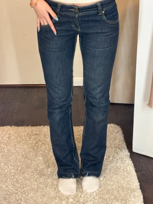 Mörkblå bootcut jeans med kontrastsömmar - Snygga mörkblå bootcut jeans med kontrastsömmar. Jeansen har låg midja och lätt utsvängda ben. De är perfekta i längden på mig som är 168.