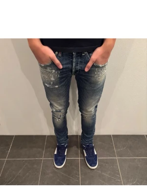 Dondup George jeans  - Säljer ett par blå jeans från Dondup, modellen George med  slim fit och slitna detaljer framtill. Jeansen har en tvättad look med ljusa partier och trasiga effekter vid knäna. Nyskick använd max 4 gånger, nypris-4000kr mitt pris-1099kr
