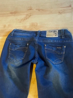 Blå lågmidjade bootcut jeans  - Mörkblå bootcut jeans i fint skick! 