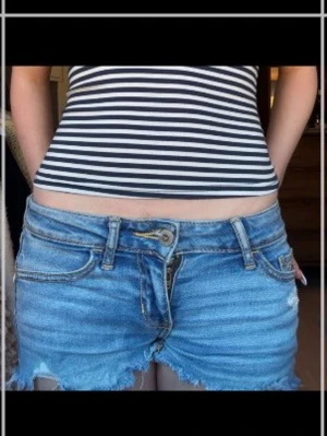 Blå jeansshorts  - Säljer ett par blå jeansshorts från hollister. Shortsen har låg midja.                                                     Midjemåttet är 31cm raktöver men passar mig som har 36cm.