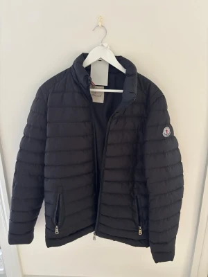 Moncler Pufferjacka  - Säljer denna moncler jacka då jag ej använder den. Det låga priset beror på min osäkerhet på om den är äkta. Denna är perfekt för dig som vill använda moncler men inte vill bli luspank!