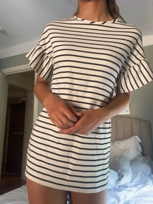 Randig kort klänning med volangärm - ❣️Gammal bildtagning❣️Snygg kort klänning med svarta och vita horisontella ränder. Klänningen har rund halsringning och korta volangärmar som ger en trendig look. Perfekt för varmare dagar och enkel att styla. Passar Xs Materialet känns mjukt och bekvämt mot huden.