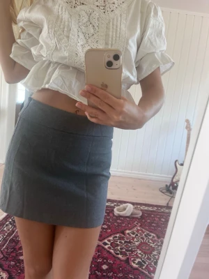 Grå kortkjol - Highwaist med diskret kedja på sidan. Kostymbyx material.