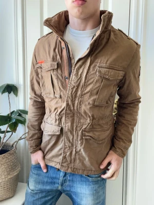 Superdry fieldjacket  - Superdry fieldjacket - fodrad som ni ser på sista bilden. Inga defekter! Modellen i bilderna är 180 cm 75 kg och bär Storlek L passar mer M , Kom med frågor! 🌟 (Kan gå ned i pris vid köp av paket 😉) 
