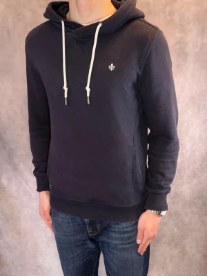 Marinblå Morris Hoodie - Stl S - Riktigt fet Morris Hoodie i deep marinblå med vitt märke! | Mycket bra skick: 9/10, utan defekter, minimalt urtvättad, inget som märks vid användning | Stl S | Modellen är 177cm lång och väger ca 74kg | Hör av dig vid frågor // Galgen 🫡