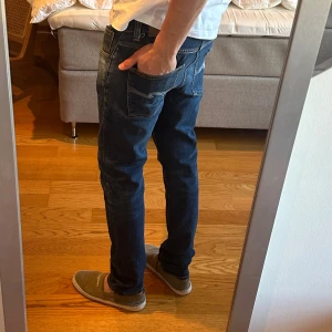 Mörkblå nudie jeans - Modell: Lean Dean Storlek: W32 L34. Bra skick förutom ett hål inuti vänster ficka 