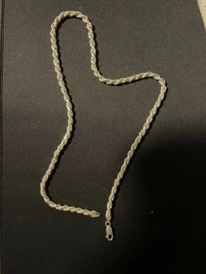 Cordell Silver halsband  - Säljer ett stilrent halsband i silverfärg med tvinnad kedja. Halsbandet har en snygg, glansig finish och ett klassiskt lås. Perfekt för dig som gillar enkel men elegant design. Materialet är silver med sterling 925 stämpel, 50 cm 