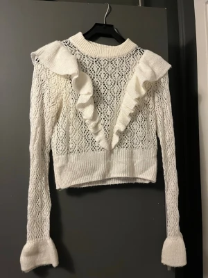 Vit spetsstickad tröja med volanger - Trendig vit stickad tröja. Små täcken på användning men inget synligt. Pris kan diskuteras! Köptes för 350