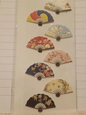 Koreanska klistermärken  - 8 st koreanska klistermärken som ser ut som solfjädrar med olika motiv. De är gjorda av kartong/papper och är handgjorda. Paketet är helt oöppnat, säljer alla tillsammans.
