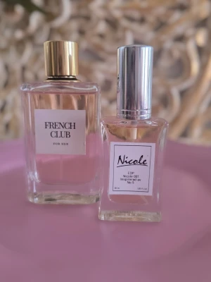 French Club & Nicole parfym duo - Två eleganta parfymer: French Club For Her med guldigt lock och Nicole EDP med silverfärgat lock. Båda flaskorna är rektangulära i transparent glas och innehåller ljusrosa vätska. Perfekt för dig som vill ha en unik doftsamling.