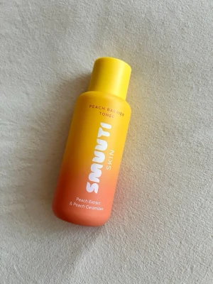Smuti Skin Peach Barrier Toner - Fräsch toner från Smuti Skin med persikoextrakt och ceramider. Flaskan är i plast med en snygg gul till persikofärgad ombre och rymmer 130 ml. Produkten är vegansk och parfymfri, perfekt för dig som vill boosta hudens fuktbarriär. 