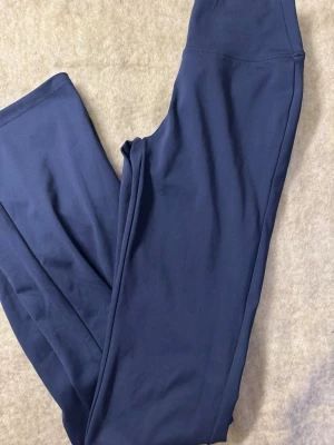 Mörkblå leggings i stretchigt tyg - Snygga mörkblå leggings i ett mjukt och stretchigt material. De har en hög midja och en slät, enkel design utan synliga detaljer eller fickor. Perfekta för en avslappnad och bekväm stil.