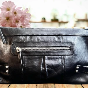 Stor Clutch från Wera! - Stor svart clutch i skinn med flera fack, dragkedja och snygga detaljer från Wera. Mått: 35 x 20 cm. Jättebra skick!