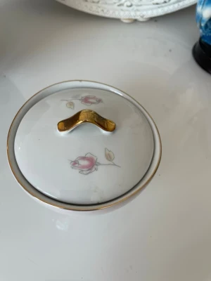 Vit vintage   Bavaria socker  skål med rosdekor - Söt vintage socke skål  bevaria  i vitt porslin med lock, dekorerad med rosa rosor och guldfärgad kant samt handtag. Perfekt för småsaker eller smycken. Klassisk och elegant design som passar i de flesta hem.